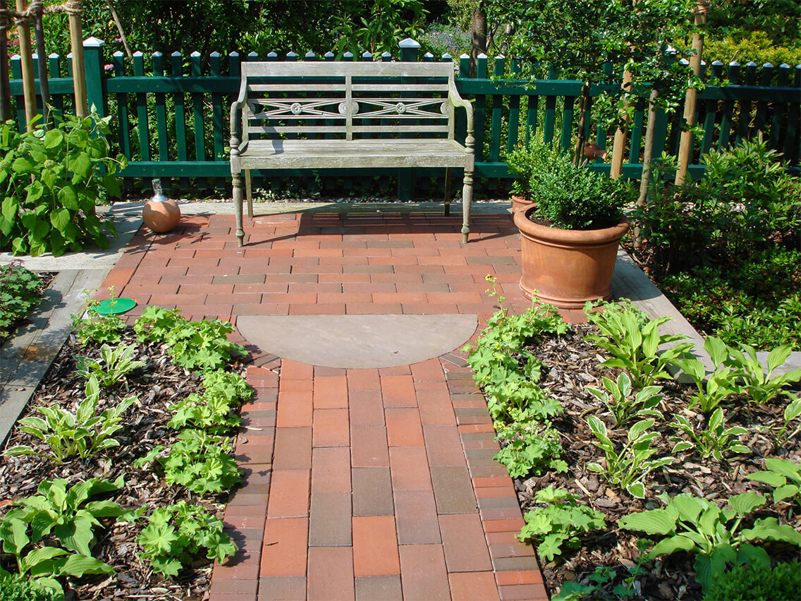 Gartengestaltung Vorgarten mit Klinger Wegpflasterung und Sitzecke mit Blumenbeeten